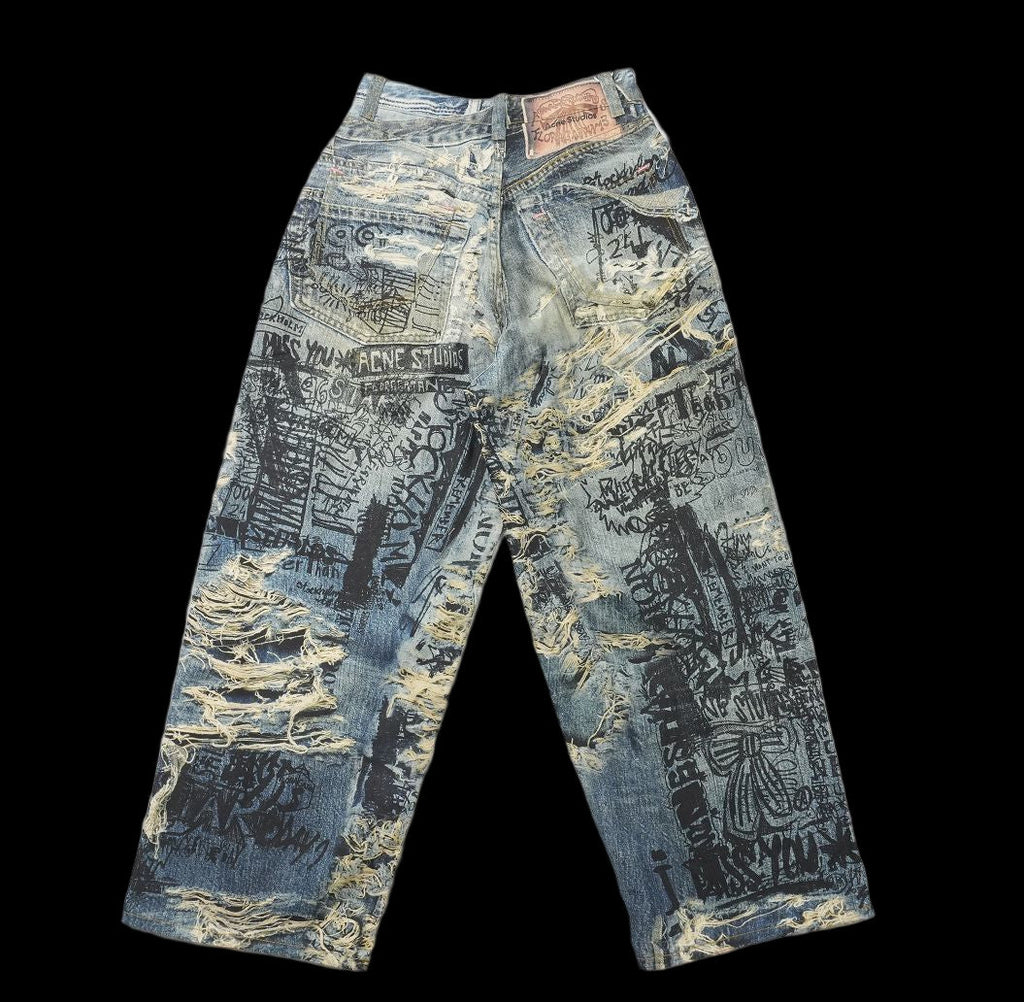 Acne Studios distressed denim jeans with all-over black scribble print.