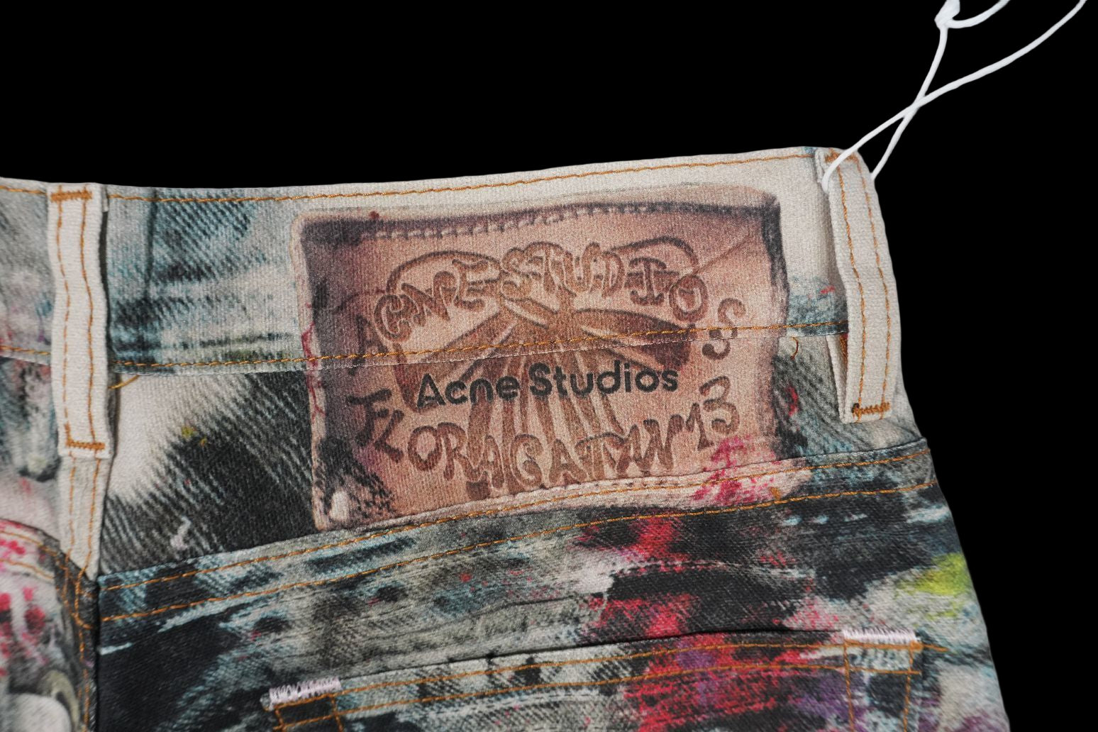 Acne Studios 1981 wide-leg jeans with a trompe l'oeil print and leather logo patch.