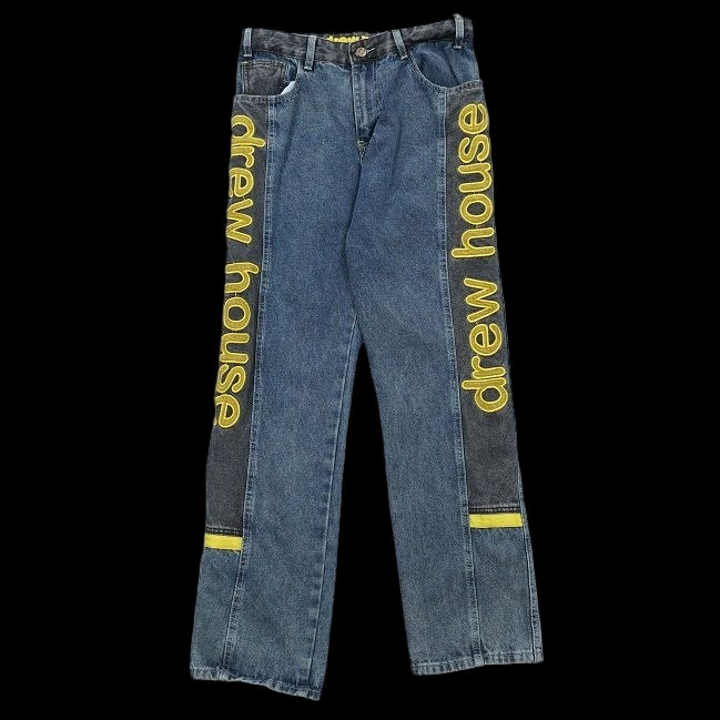 Drew House wide leg denim jeans with yellow text down the sides.