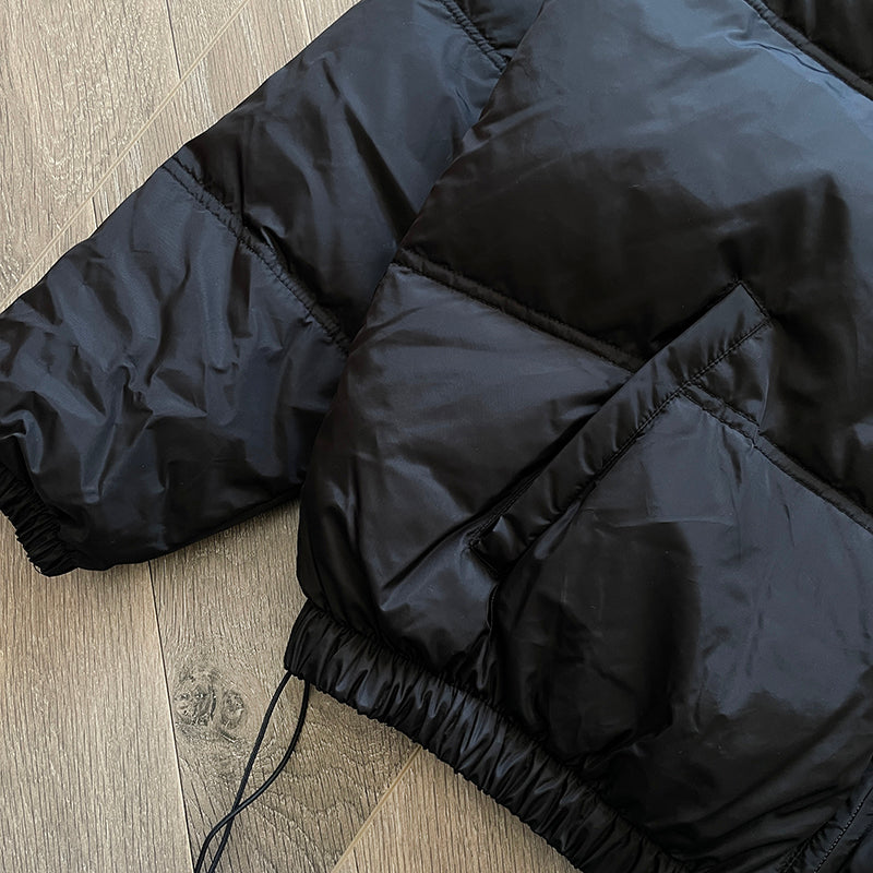 Black puffer jacket with a sleek design and tailored fit for warmth and style.